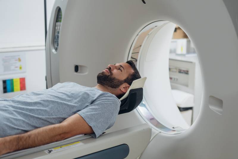 A male patient lying on a CT table waiting for the scan.