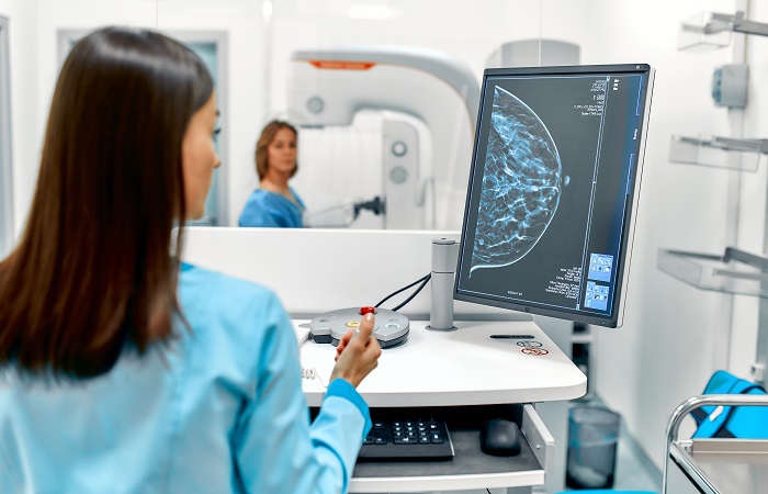 A radiologist conducts mammogram on a patient and the results getting displayed on a monitor.