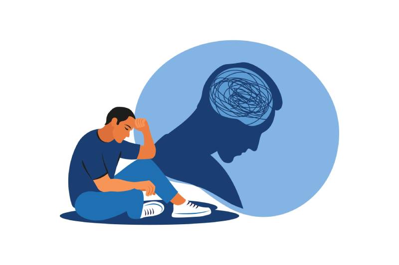 A vector image of a depressed man sitting on the floor supporting his head with a hand and an illustration of his stress shown as a shadow image.