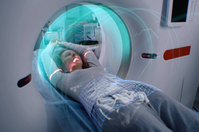 A VFX image of a women undergoing a CT scan inside the scanner.