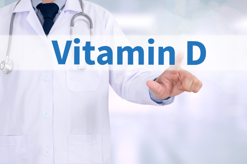 A doctor touching the word VITAMIN D on a virtual screen in front of him.