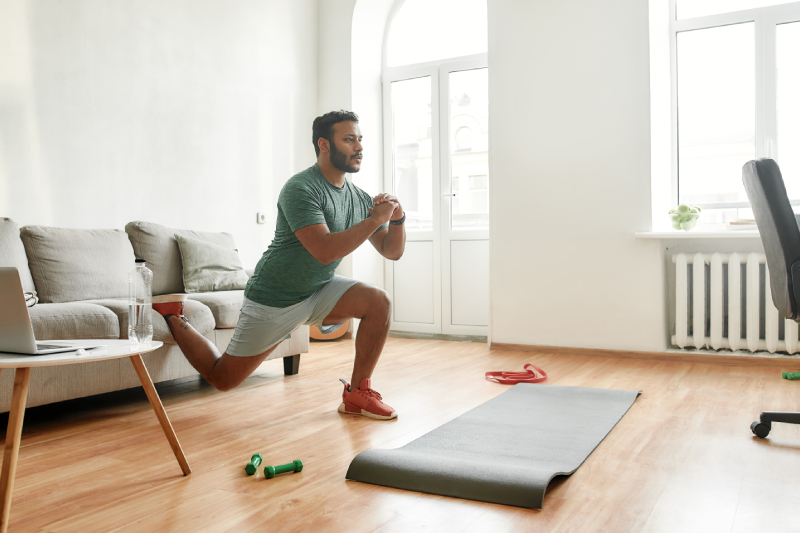 Image of a man doing stretching during a morning workout in his living room.