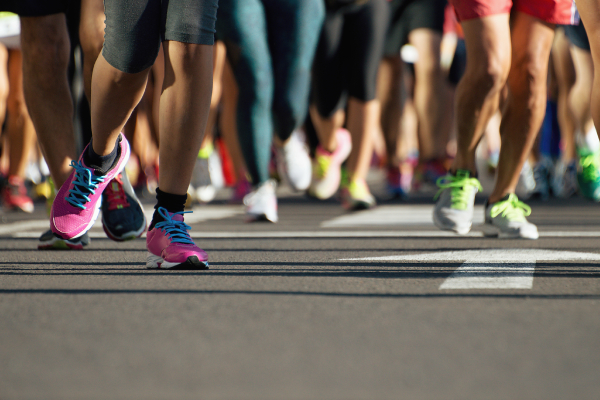 Close up view of runners feet with running shoes on, captured during a marathon run.