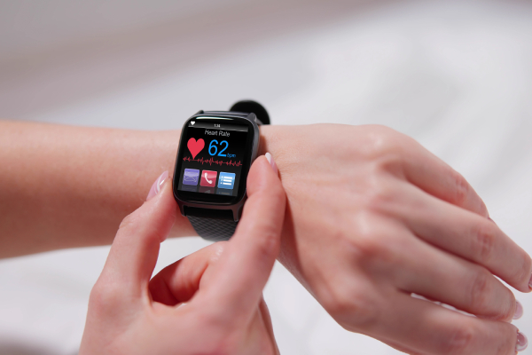 A woman checking the smart watch worn on her hand,displaying her heartbeat monitor readings.