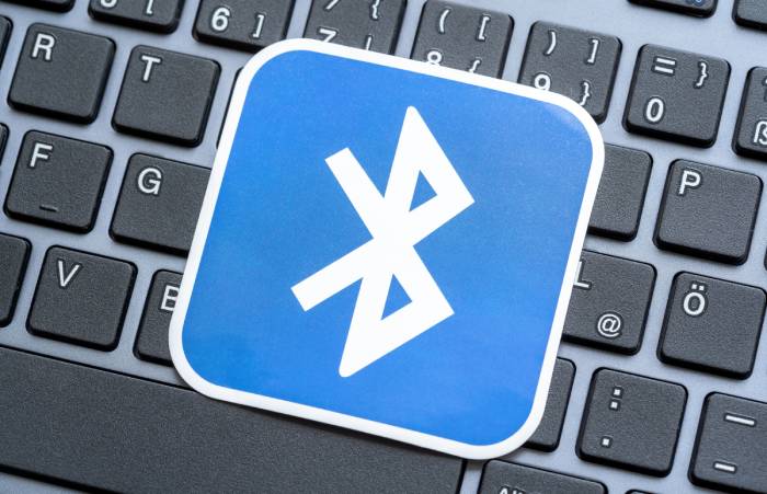 An enlarged bluetooth logo kept over a laptop keyboard.