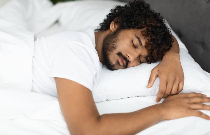 Close up view of a man sleeping peacefully in his bed.