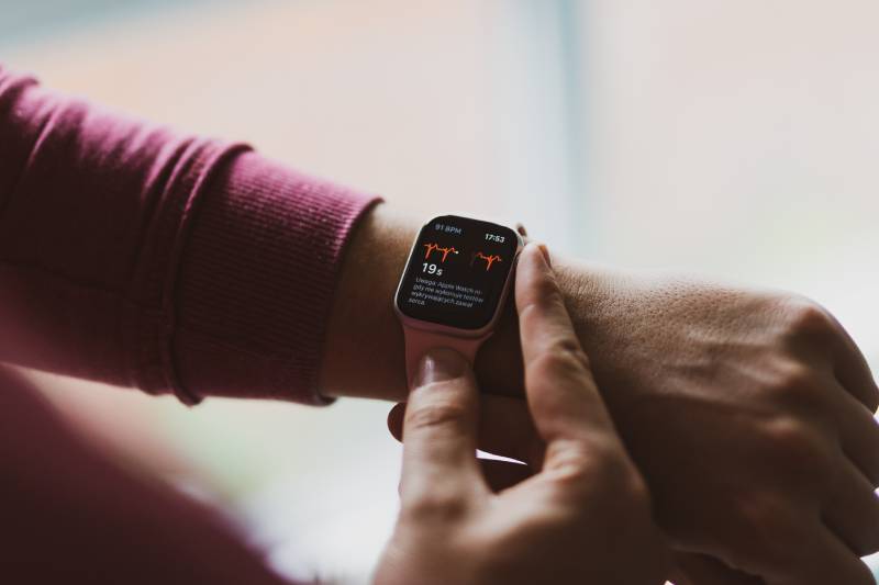 A man using digital watch to check his heart rate.