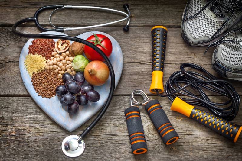 A balanced diet, stethoscope, and physical fitness symbolize a healthy lifestyle.