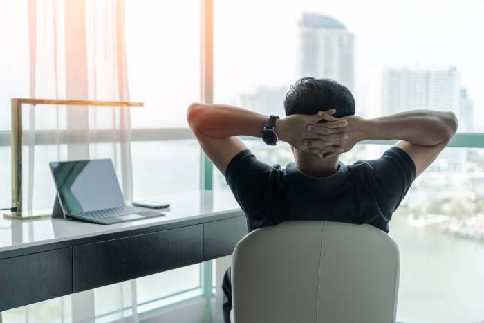 Rear view of a man sitting relaxed in his office after work.