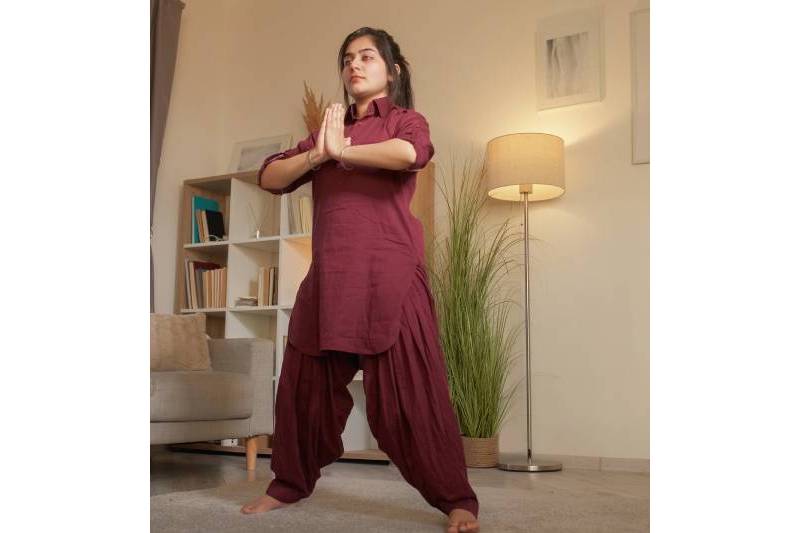 A young woman practicing yoga in a living room.