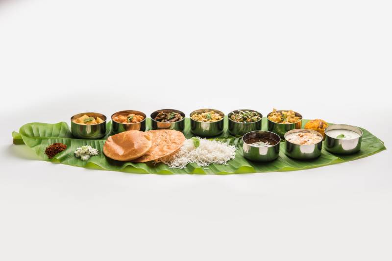 A complete Indian meal served on a big banana leaf.