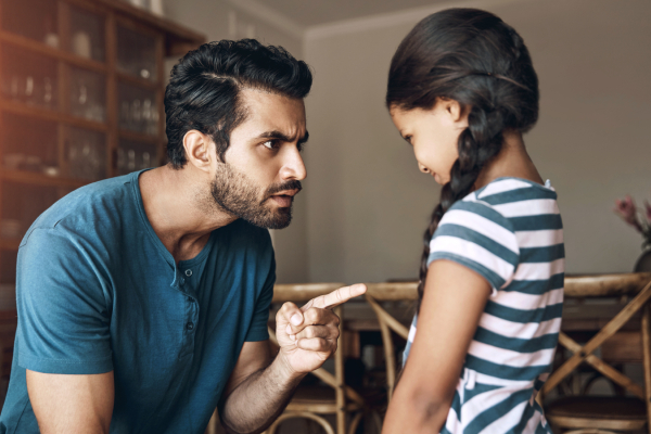 Father scolding his daughter, who looks down sadly, reflecting challenges in the parent-child relationship.