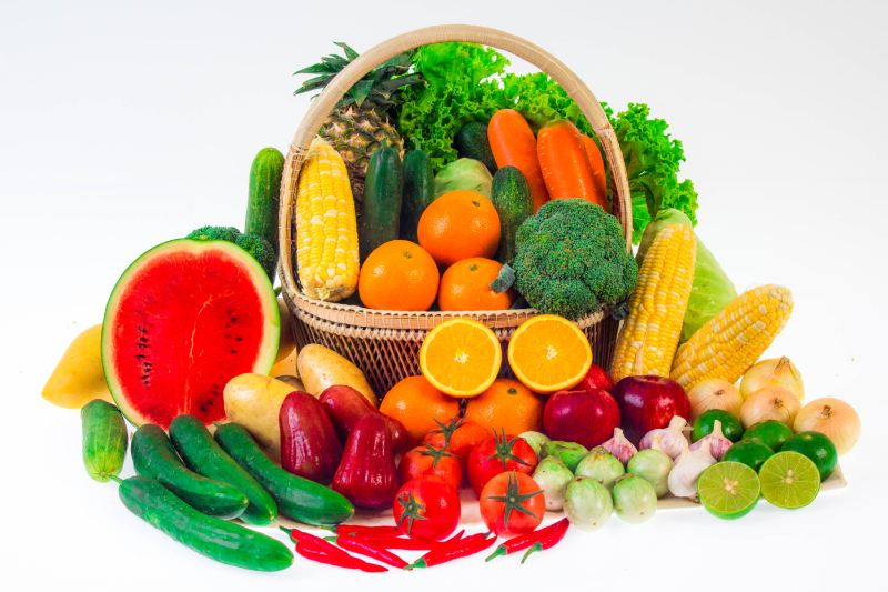 Fresh organic fruits and vegetables in a wicker basket, highlighting the importance of healthy foods for nutritional balance.