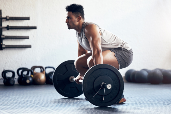 A man performing a deadlift in a gym, symbolizes strength, mental calmness, and stress relief.