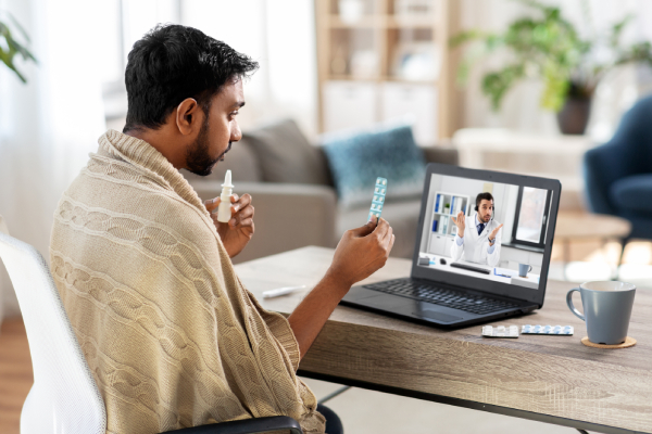 A person using a tablet and a nozzle, consulting a doctor online for prompt medical guidance on daily health matters.